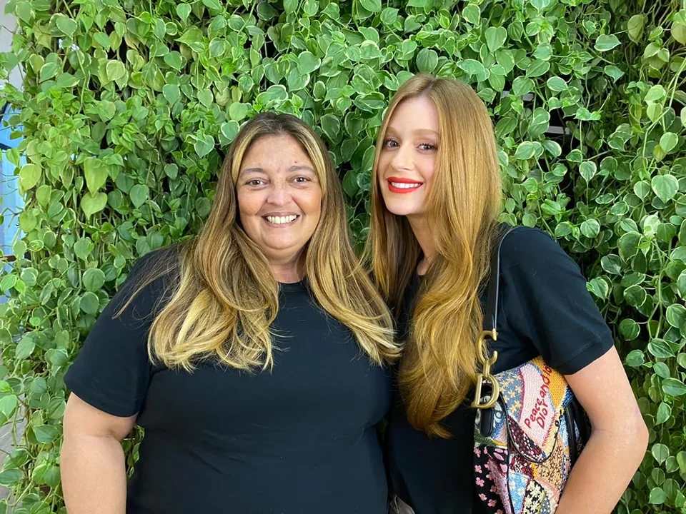 Renata e Marina sorrindo em um encontro no salão.
